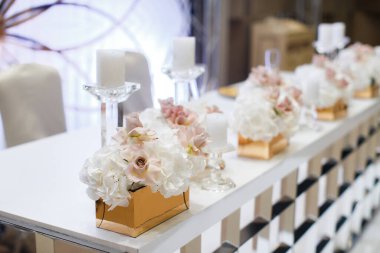 Düğün masasında vazodaki çiçek buketleri.