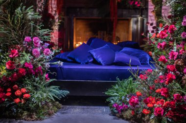 Çiçekler ve mumlarla süslenmiş şömineli yatak.