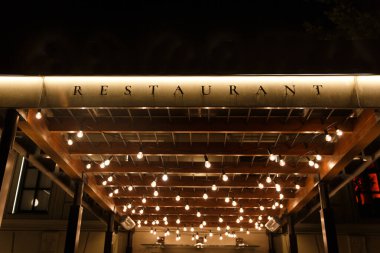 Bir sürü ışığı olan bir restoranın gece manzarası..