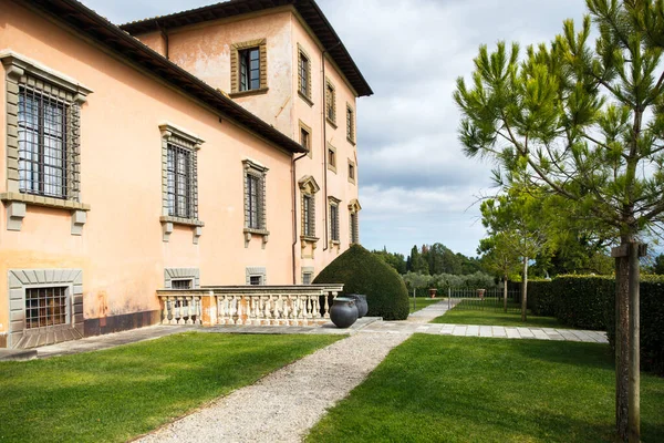 Italian villa with green lawn and trees.