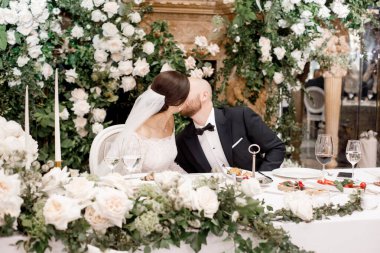 Gelin ve Damat Düğün masada öpüşme.