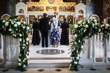 Gelin ve damadın tanıkları kilisedeki törende taç giyerler.