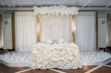 Beyaz salonda bir düğün için kemer..