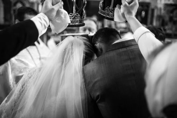 花嫁と新郎の証人は教会の儀式で冠を保持します — ストック写真