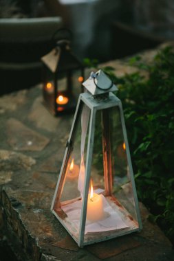 Eski bir fenerin içinde yanan küçük bir mum..