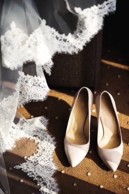 Bej rengi düğün ayakkabıları ve dantelli peçe.
