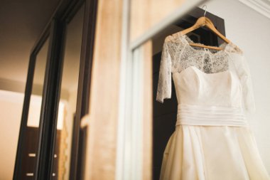 Gelinlik kapının kemerinde asılı..