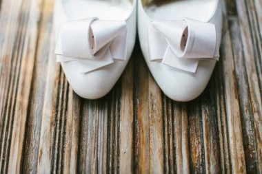 Ahşap pencere eşiğinde bej rengi düğün ayakkabıları..