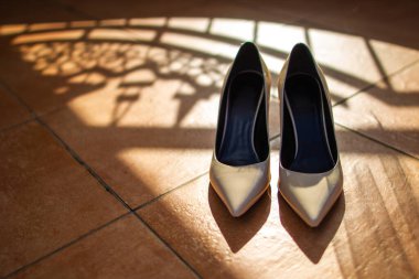 Taştan bir zeminde desenli bej düğün ayakkabıları..