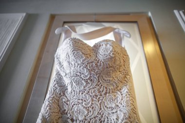 Dantelli gelinlik kapıda asılı..