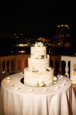 Güllerle süslenmiş çok katlı düğün pastası..