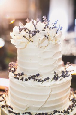 Çeşitli çiçeklerle süslenmiş çok katlı düğün pastası..