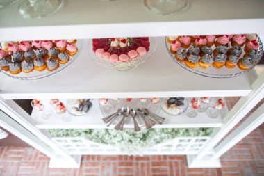 Çok renkli kremayla dekore edilmiş bir tabakta kekler.