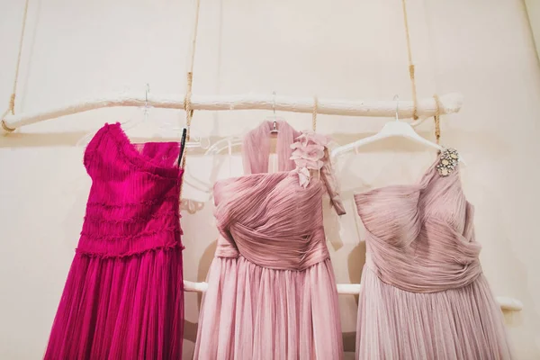 Bright dresses for bridesmaids hang on a hanger.