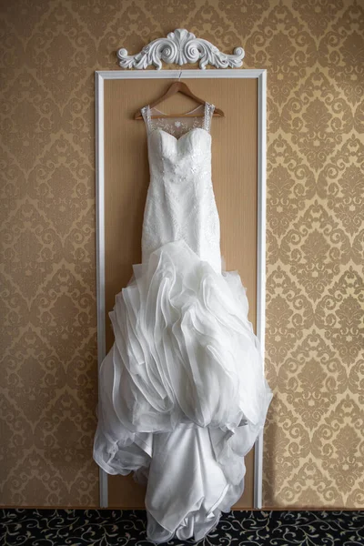 wedding dress hanging on the wall in the room.