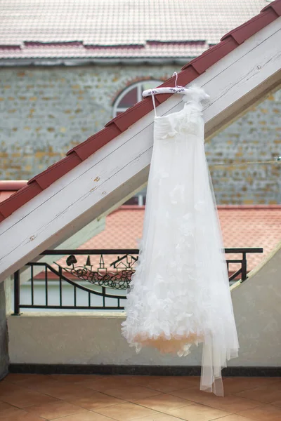 Wedding dress hanging on the roof of the balcony.