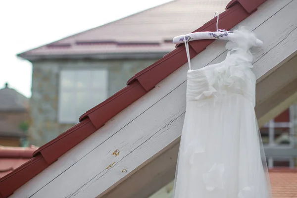 Wedding dress hanging on the roof of the balcony.