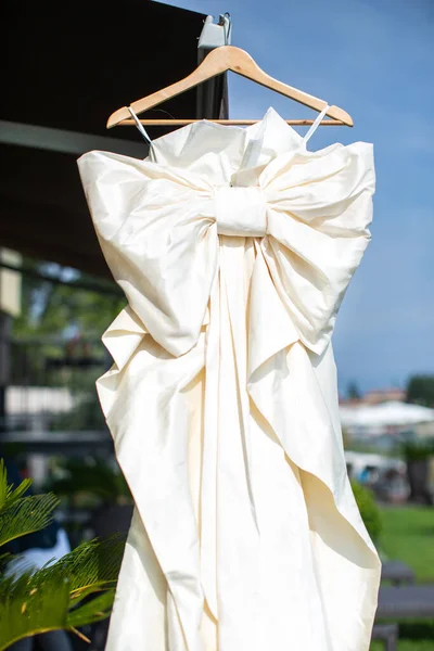 Beige wedding dress with a large bow.