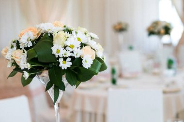 Bouquet of flowers in vase on the wedding table.