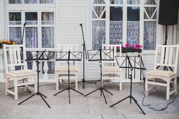 Music stands and wooden chairs at a wedding party.