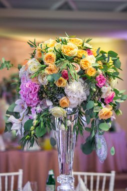 Düğün masasındaki vazoda bir buket çiçek..