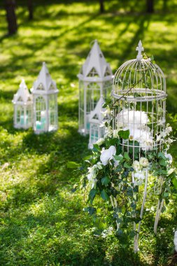 Beautiful and delicate flowers at the wedding ceremony. Flowers in a metal cage