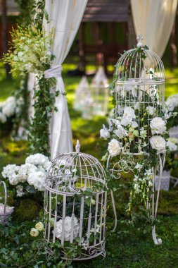 Beautiful and delicate flowers at the wedding ceremony. Flowers in a metal cage