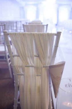 White chairs for an outdoor wedding ceremony.