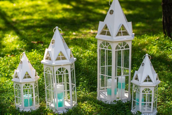 Row of wooden lanterns on green grass.