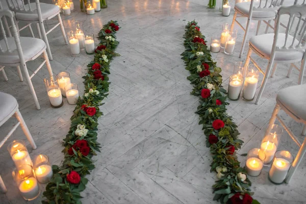 Row of bright flowers with candles at the wedding ceremony.