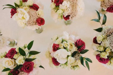 Wedding bouquets for bridesmaids in vases on the table.