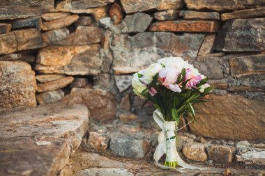 Delicate bridal bouquet on the stone floor.