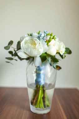 Wedding bouquet stands in a vase with water.