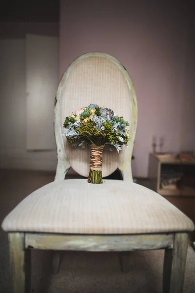 Colorful wedding bouquet on a vintage chair.