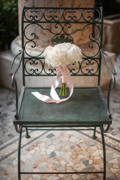 Colorful wedding bouquet on a vintage chair.