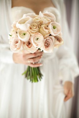 Bright wedding bouquet in hands of the bride.