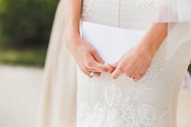 Engagement ring on bride's finger during wedding preparations.