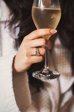 Engagement ring on bride's finger during wedding preparations.