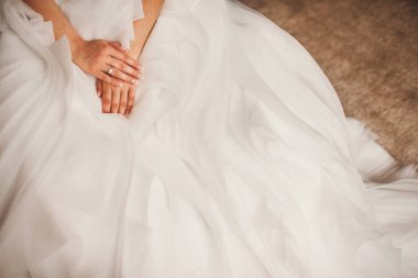 Engagement ring on bride's finger during wedding preparations.
