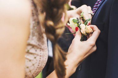 Elegant wedding boutonniere on the groom's suit.