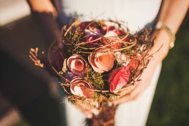 Bright wedding bouquet in hands of the bride.