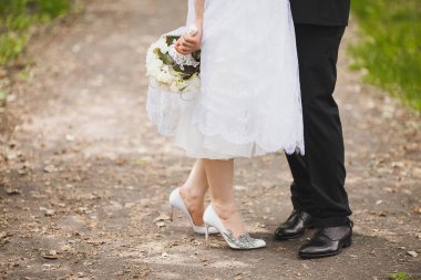Bright wedding bouquet in hands of the bride.