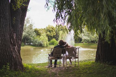 Bride and groom on their wedding day. Sitting hugging on chairs