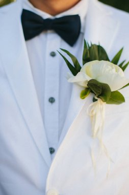 Elegant wedding boutonniere on the groom's suit.