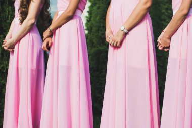 Bridesmaids in pink dresses at the ceremony.