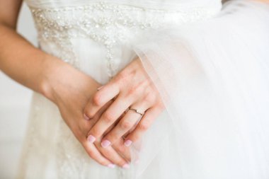 Engagement ring on bride's finger during wedding preparations.