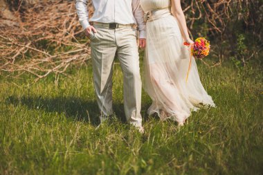 Bride and groom holding hands in the garden.