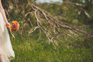 Bright wedding bouquet in hands of the bride.