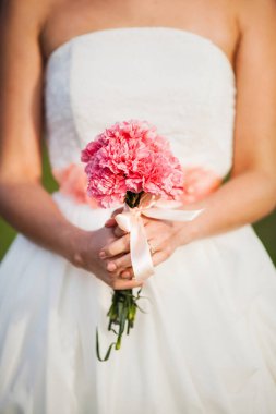 Bright wedding bouquet in hands of the bride.