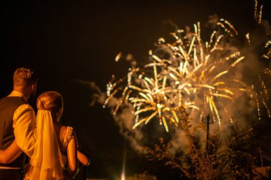 Bride and groom on their wedding day. Newlyweds watch fireworks